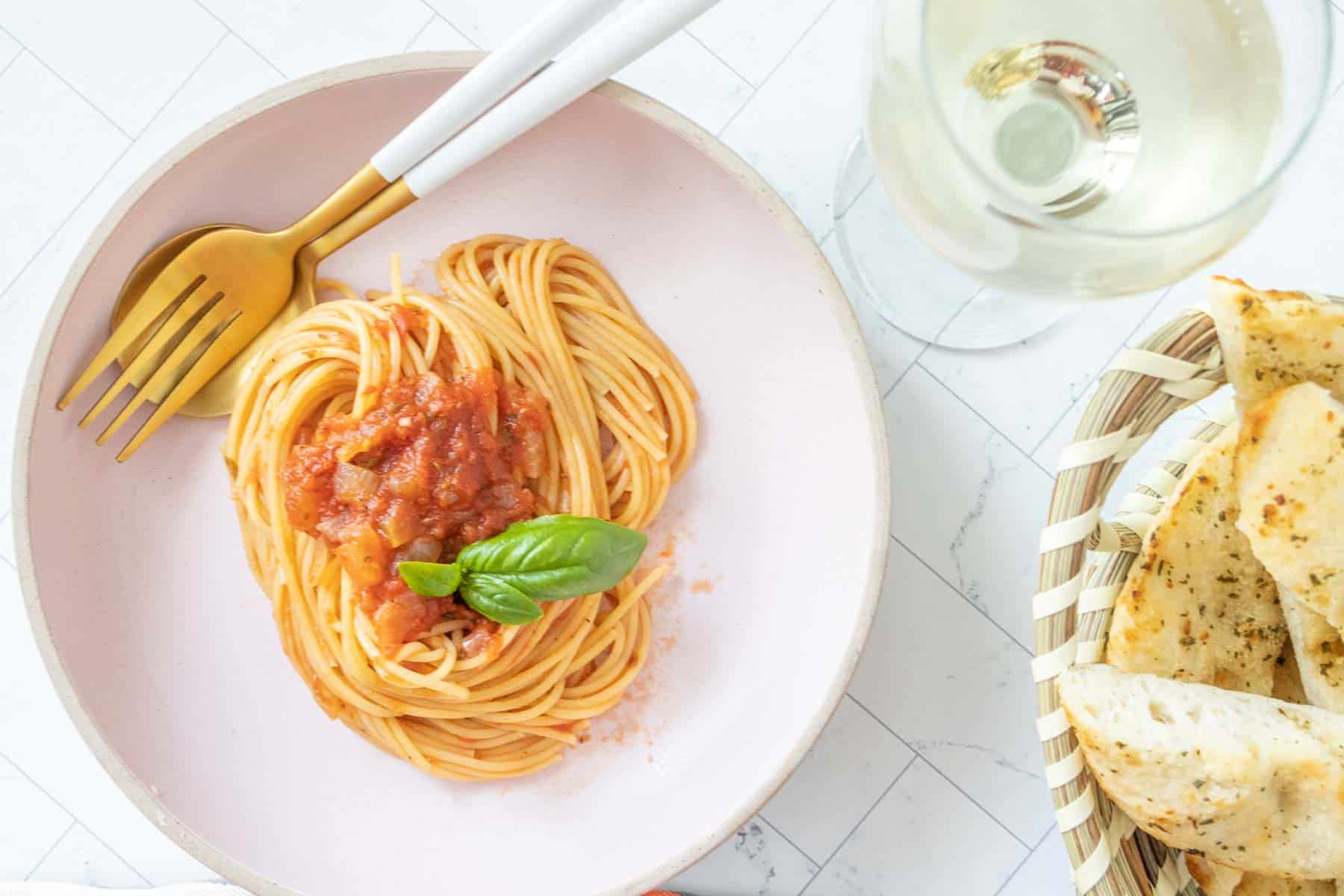 A plate of spaghetti and a glass of wine.