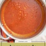 A stainless steel pot filled with red, easy spaghetti sauce sits on a striped cloth, accompanied by a label reading "homemade spaghetti sauce.