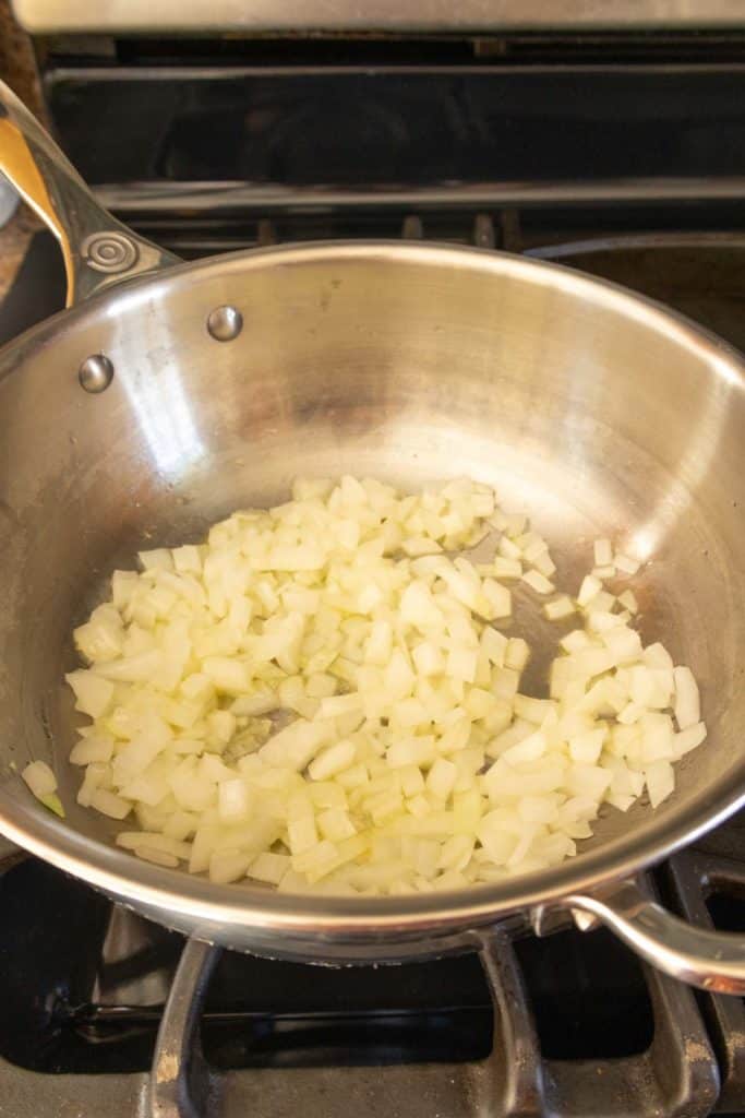 Sliced onions in a pan on a stove top.