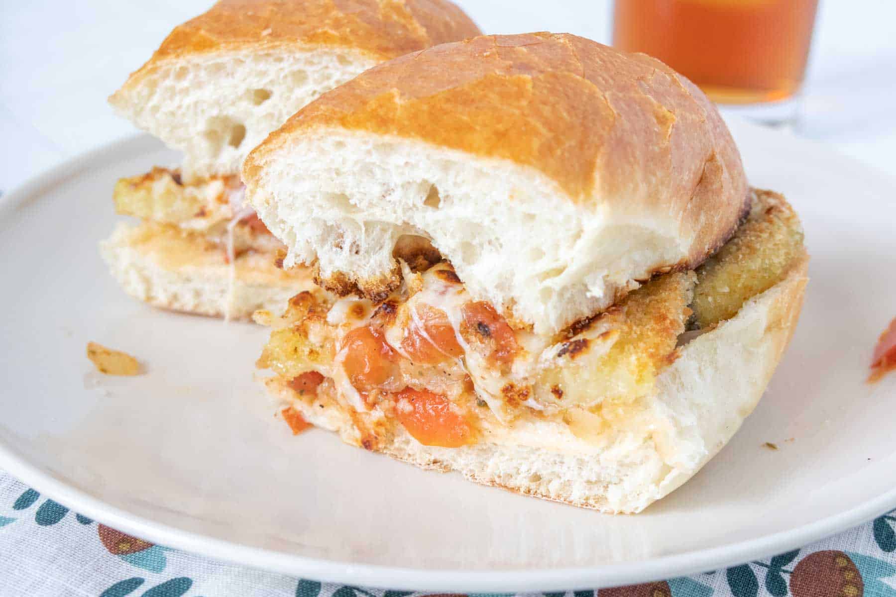 Cut eggplant parmesan sandwich on a plate.