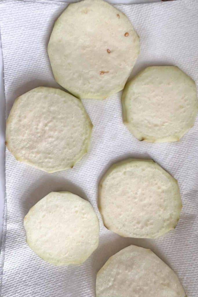 Eggplant slices drying on paper towels.