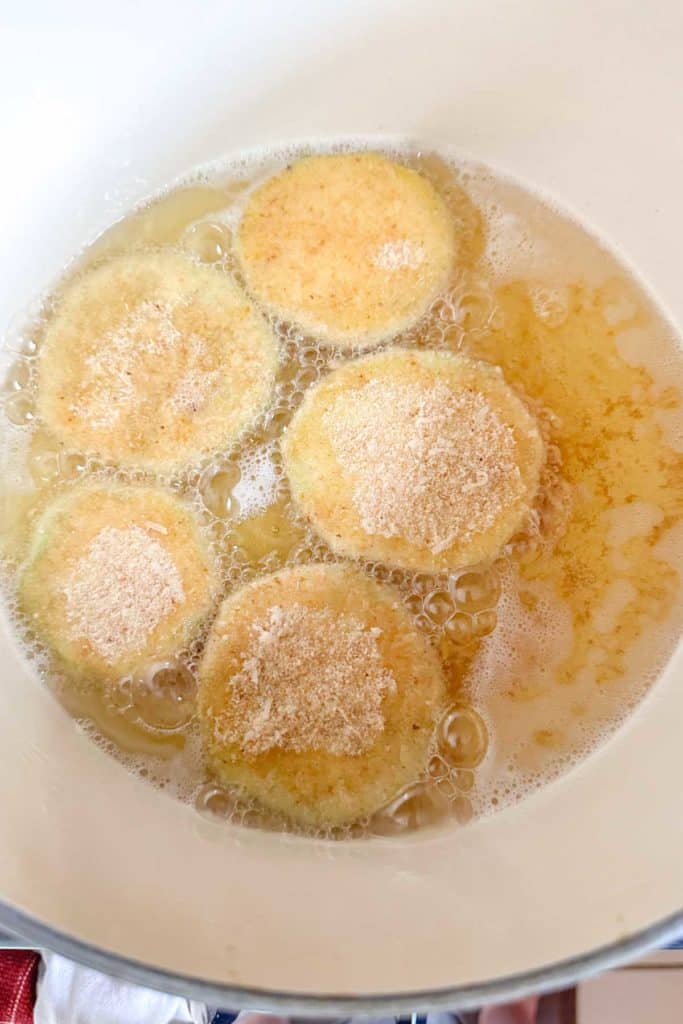 Frying eggplant rounds in a dutch oven.