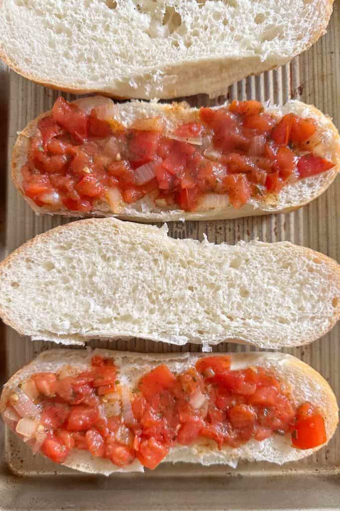 Tomato sauce spread onto hoagie rolls.