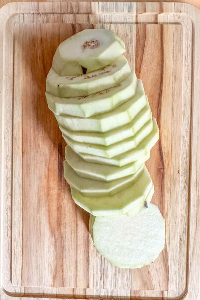 Sliced eggplant on a cutting board.