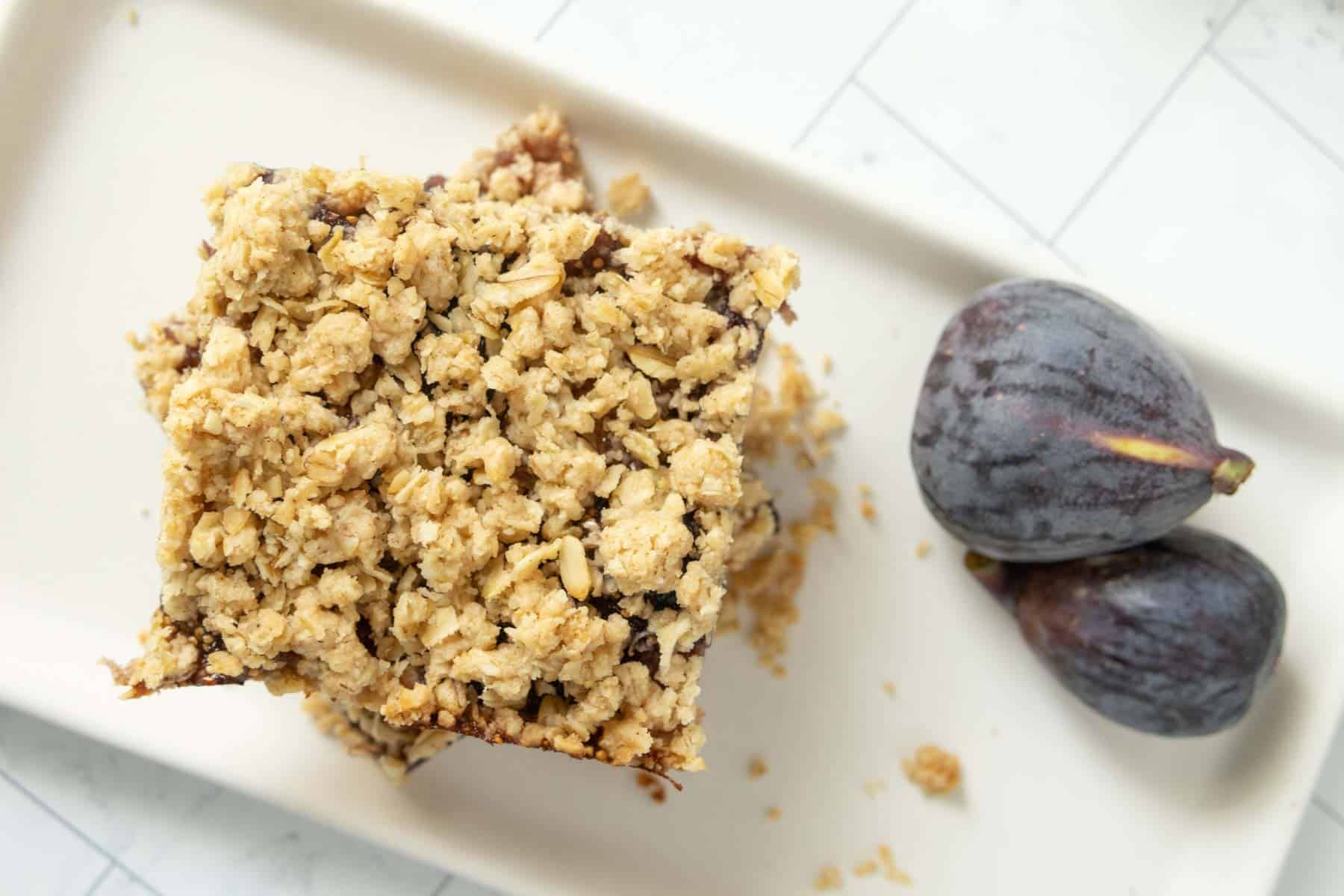 Fig bars with oats and figs on a white plate.