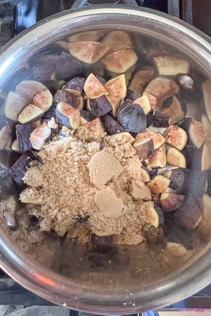 Figs and sugar in a pot on the stove.