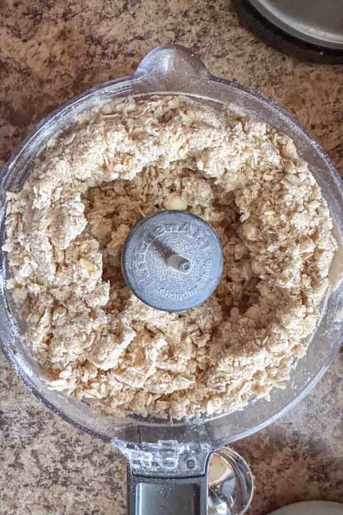 A food processor filled with a mixture of oats.