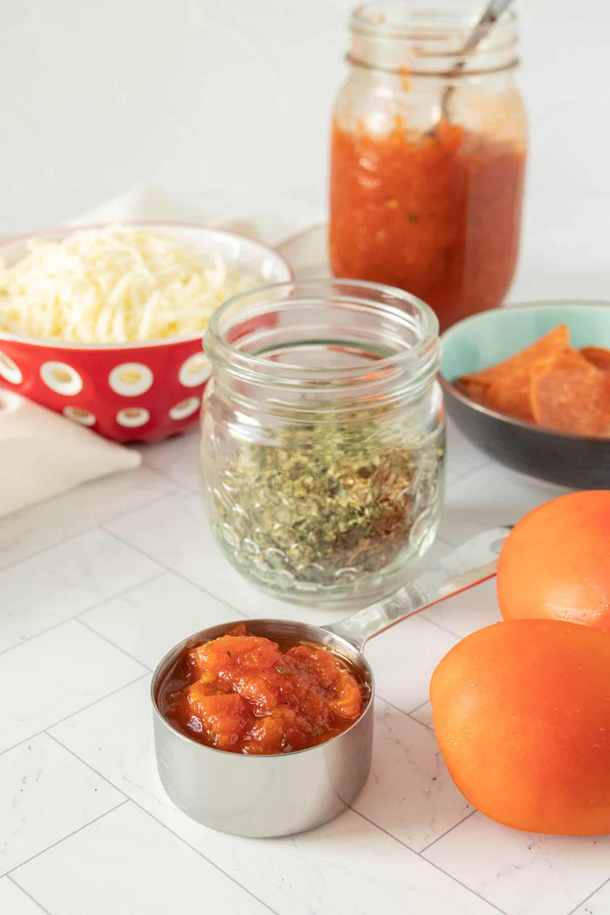 Jars of tomato sauce and other ingredients on a counter.