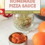 A metal measuring cup filled with chunky homemade pizza sauce sits on a counter next to fresh tomatoes and a jar of dried herbs, ready for your next homemade pizza night.