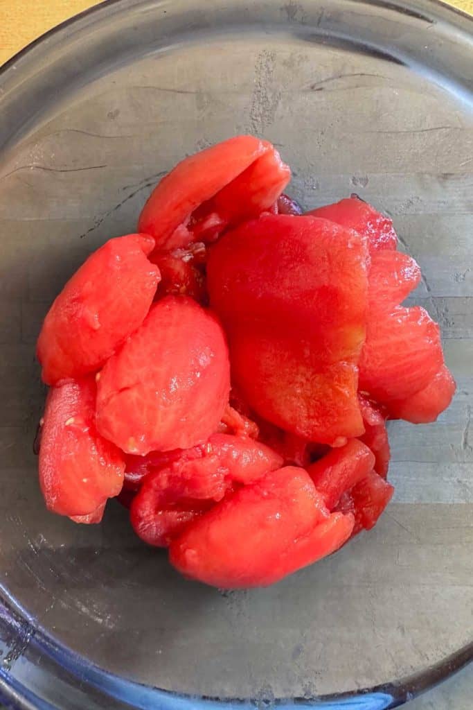 Sliced tomatoes in a glass bowl.