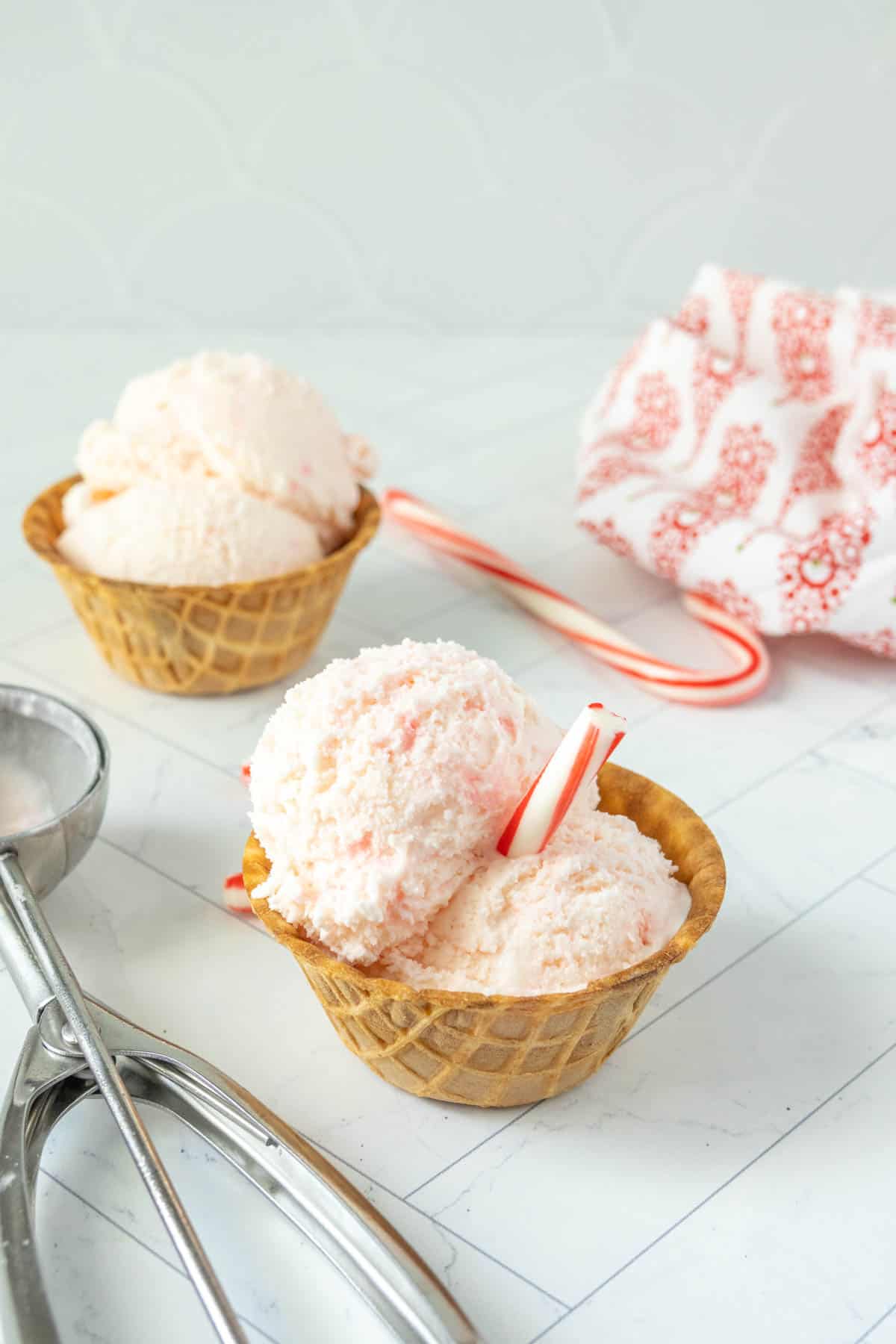 Two bowls of ice cream with candy canes.