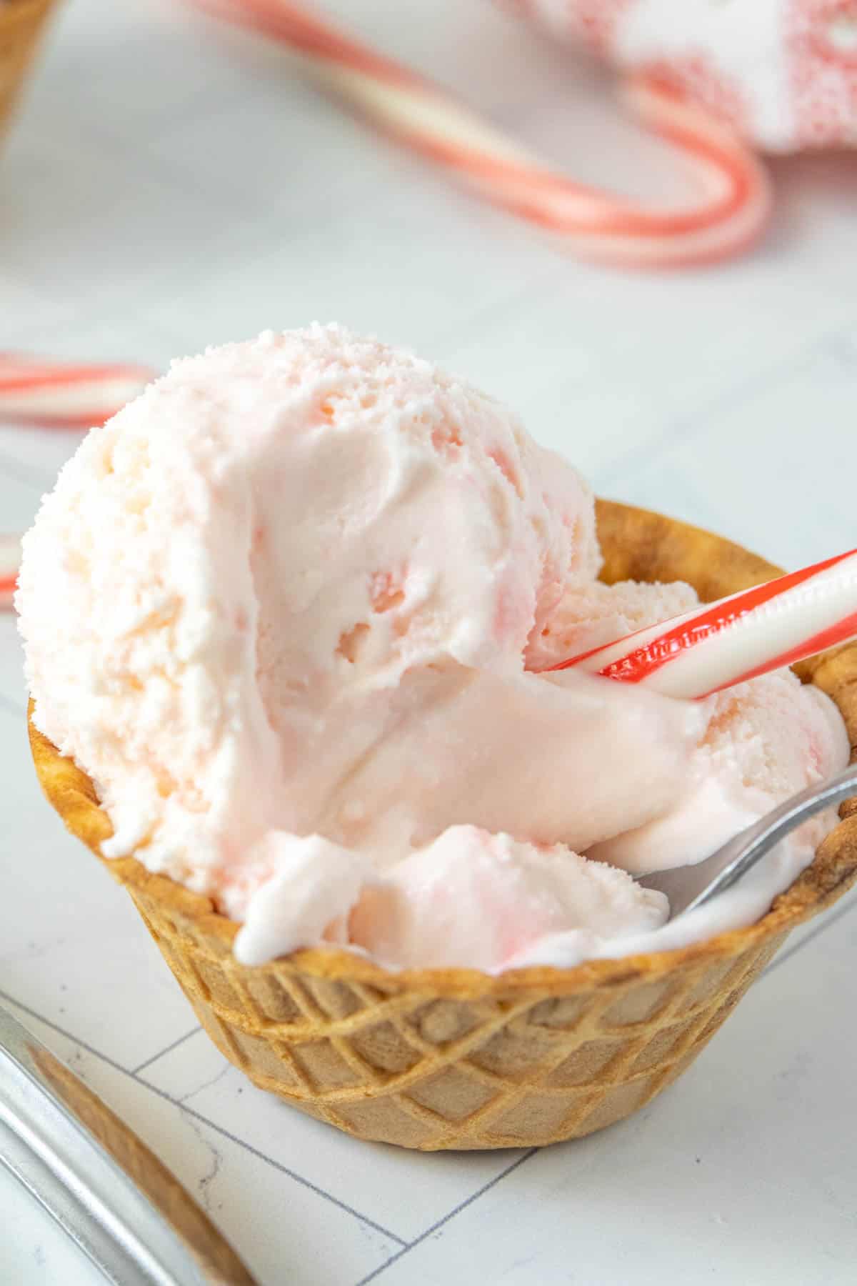 A bowl of ice cream with candy canes in it.