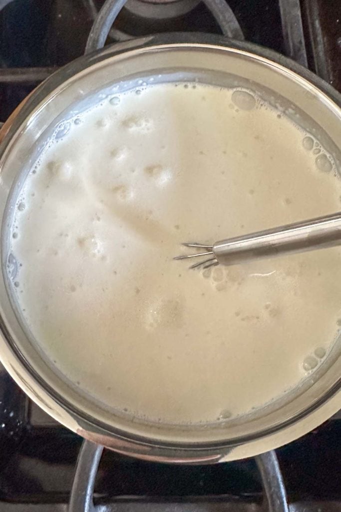 Simmering cream and sugar in a saucepan.