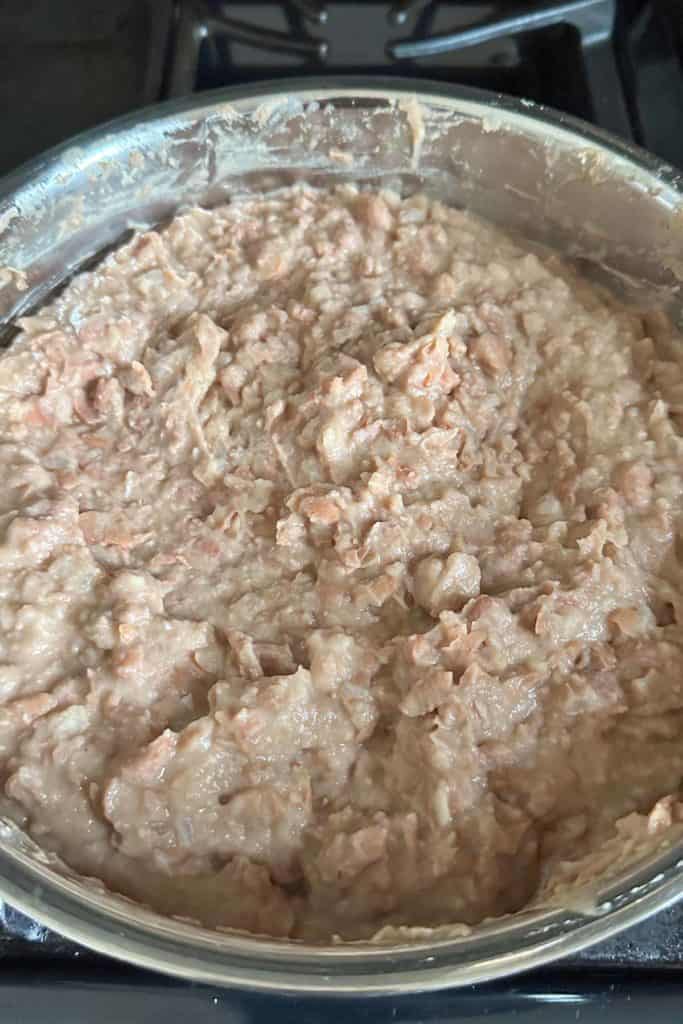 A pan of mashed refried beans on a stove top.