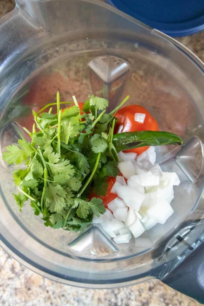 Cilantro, onions, and tomatoes in a blender.