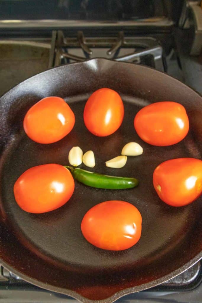 A frying pan with tomatoes and garlic.