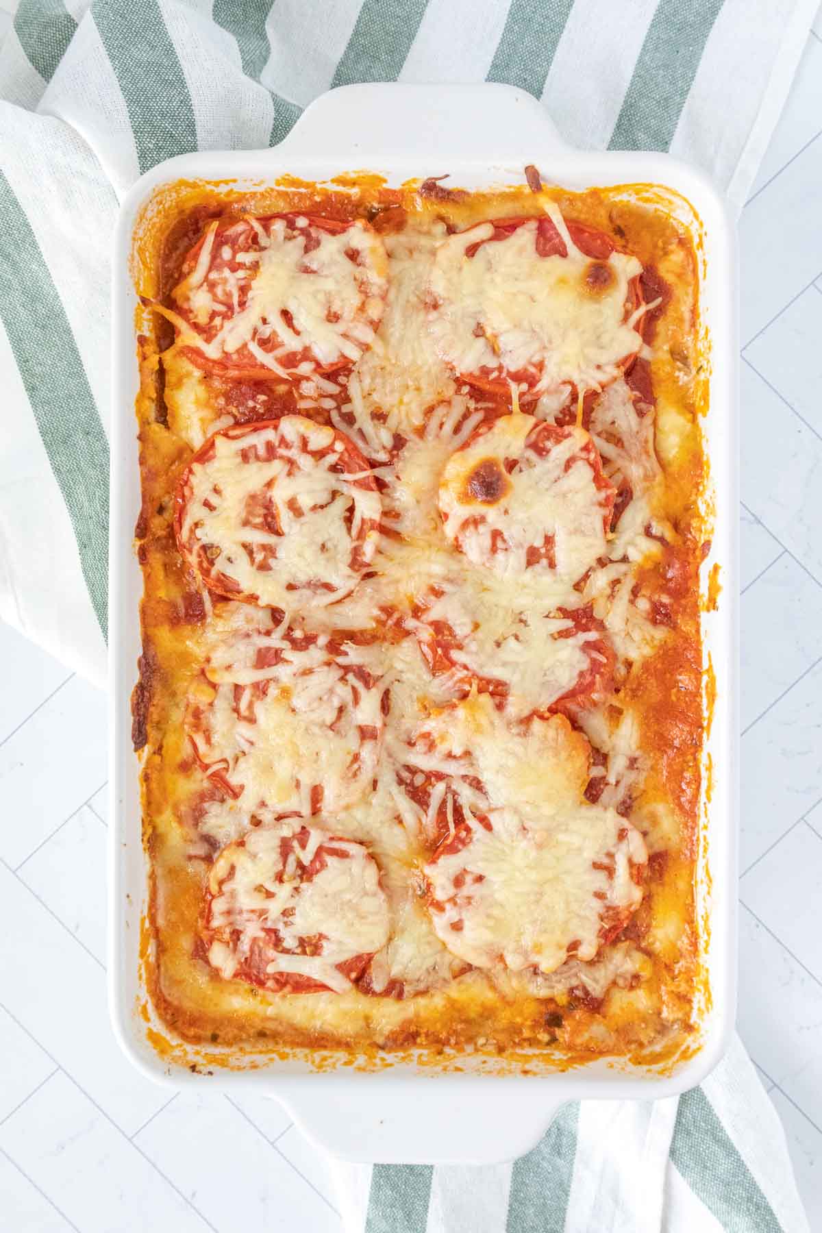 Baked zucchini lasagna in a white casserole pan.