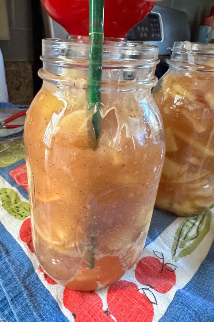 Two mason jars filled with apple pie filling.