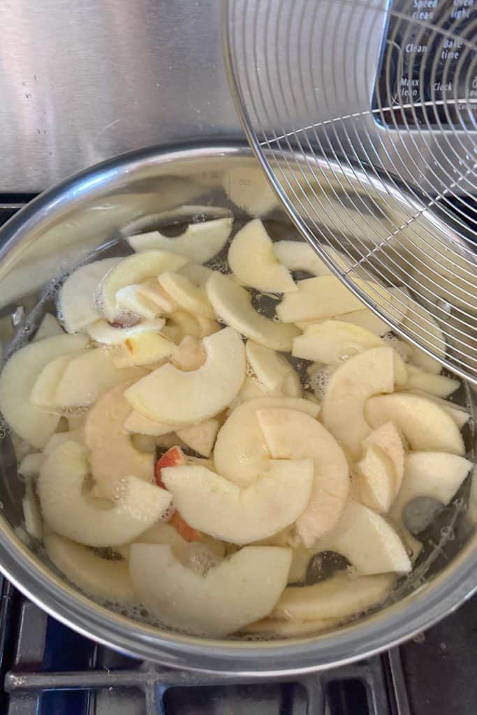 Sliced apples in a pan on top of a stove.