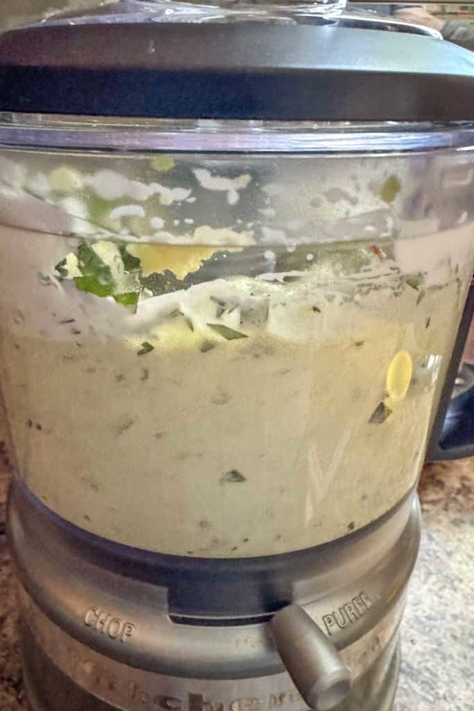 A food processor filled with a mixture of ingredients.