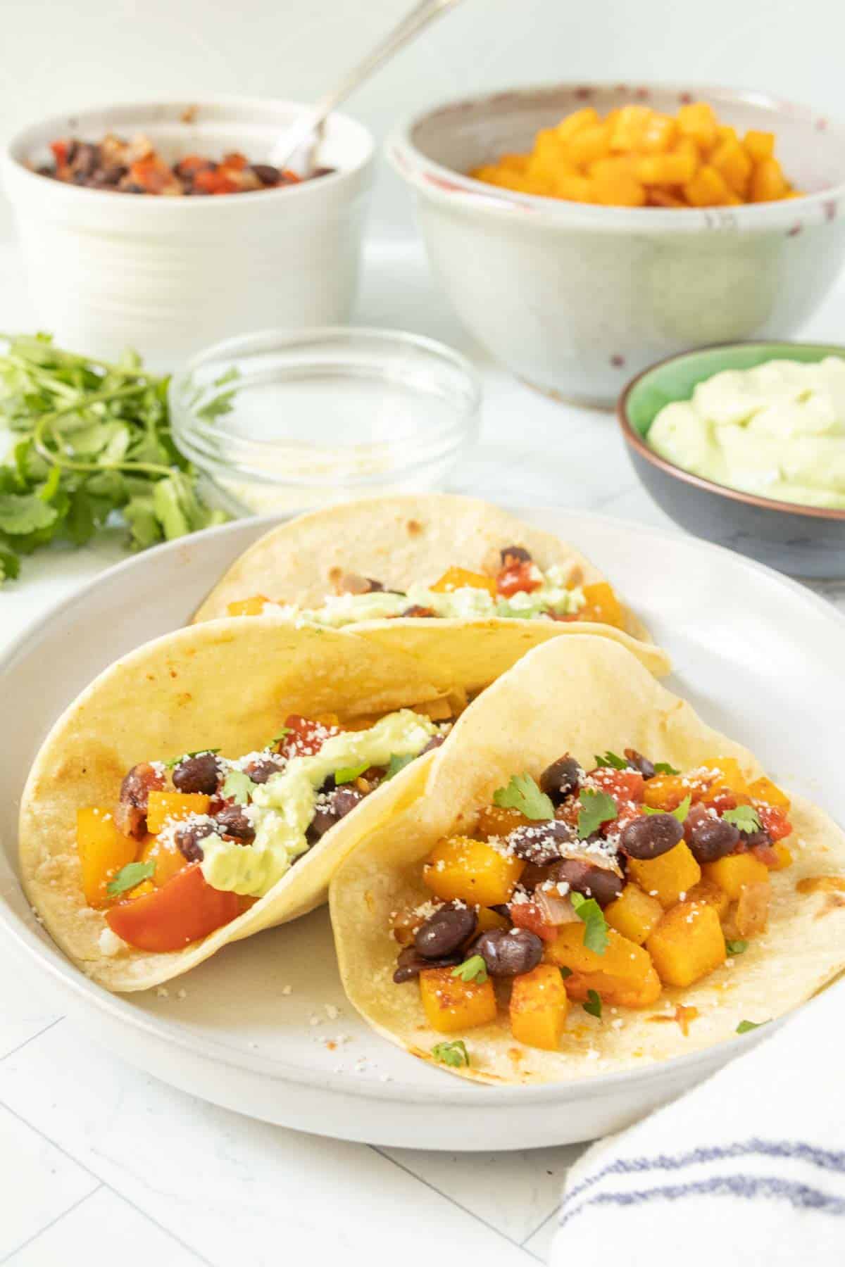 Tacos with black beans and avocado on a plate.