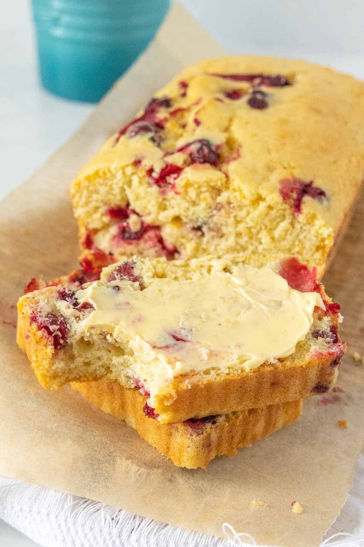 A slice of cranberry bread with butter on top.