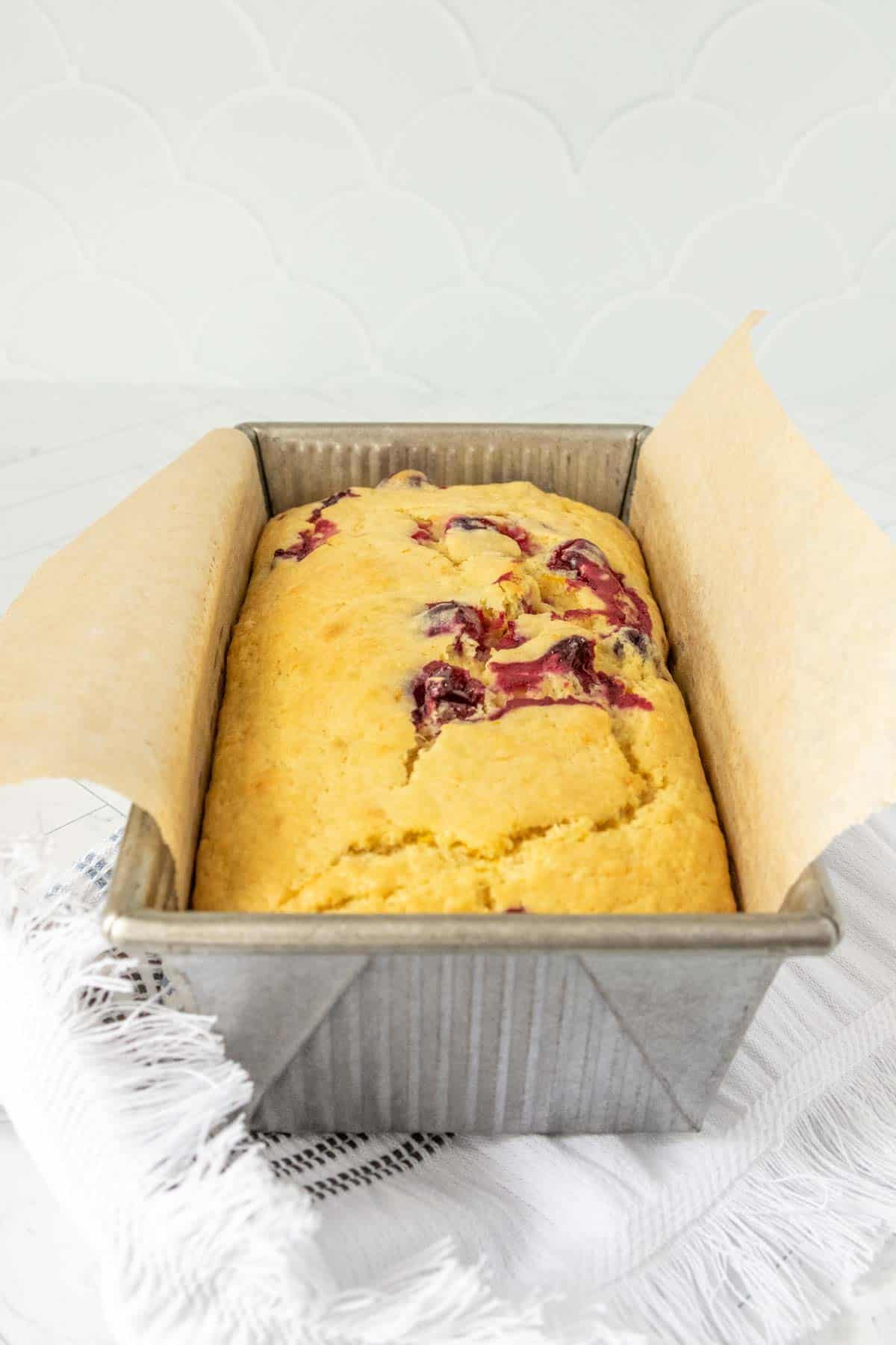 A loaf of berry bread in a metal pan.