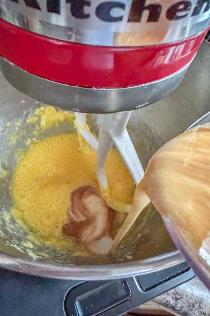 A person mixing ingredients in a kitchen mixer.