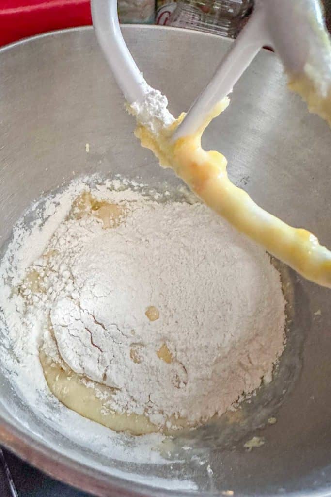 A mixer is being used to mix flour into a bowl.