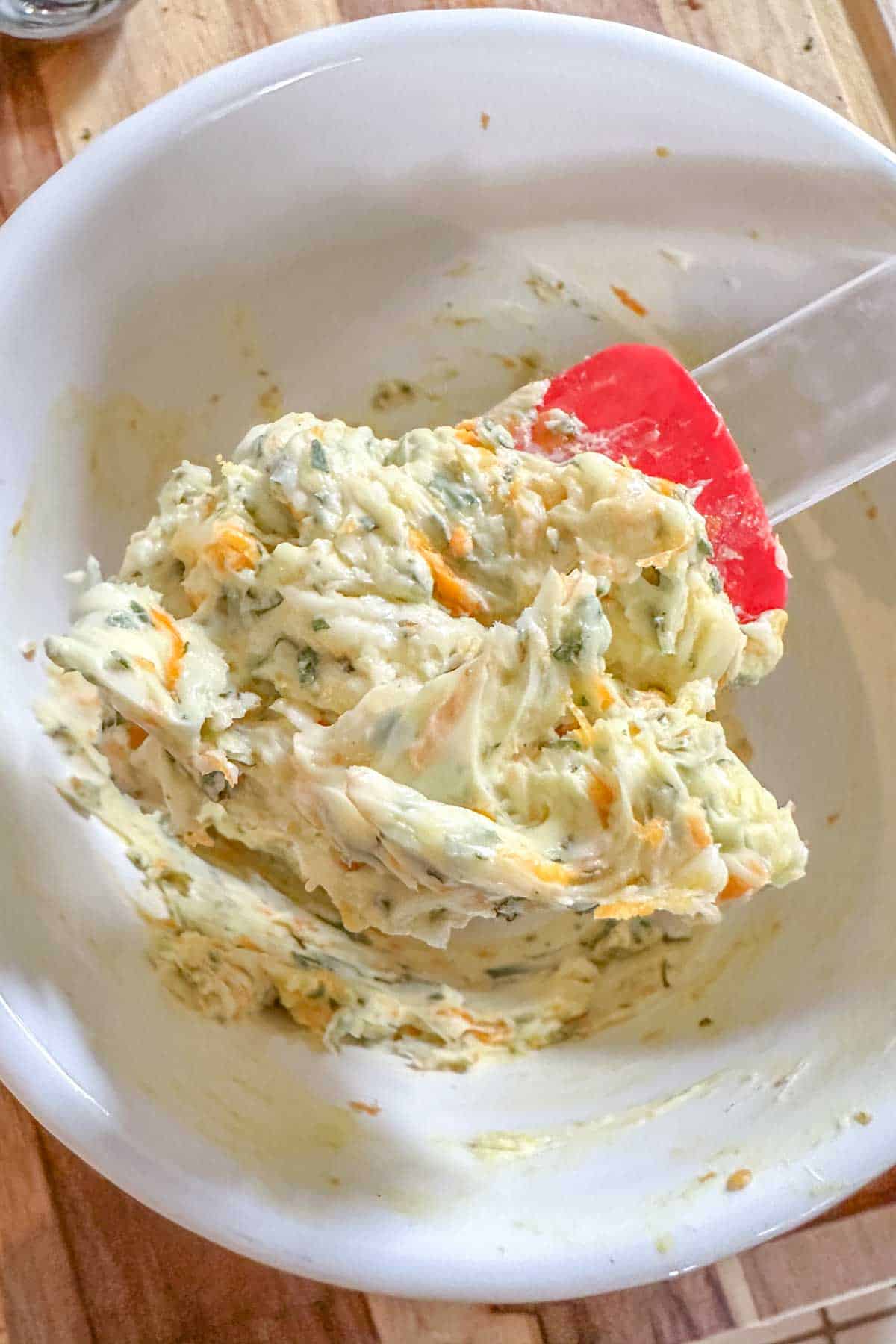 A white bowl with citrus herb butter.