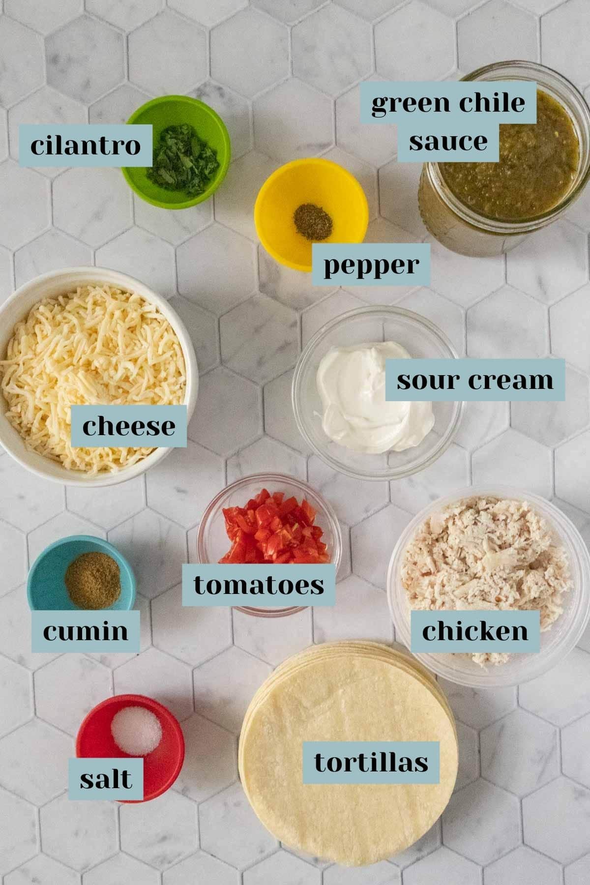 Ingredients for chicken tortillas on a marble countertop.