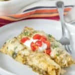 Mexican enchiladas on a plate with sour cream.