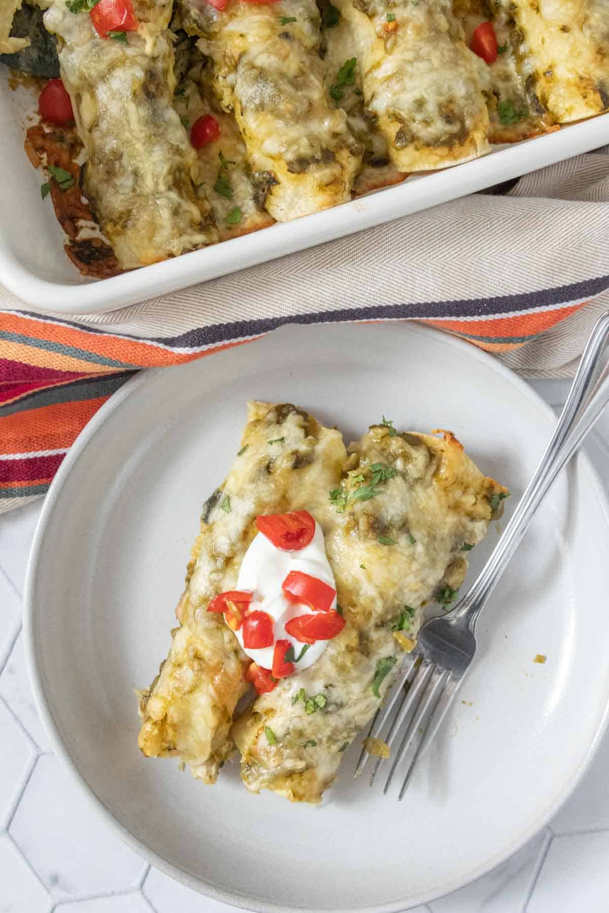 Mexican enchiladas on a plate with a fork.