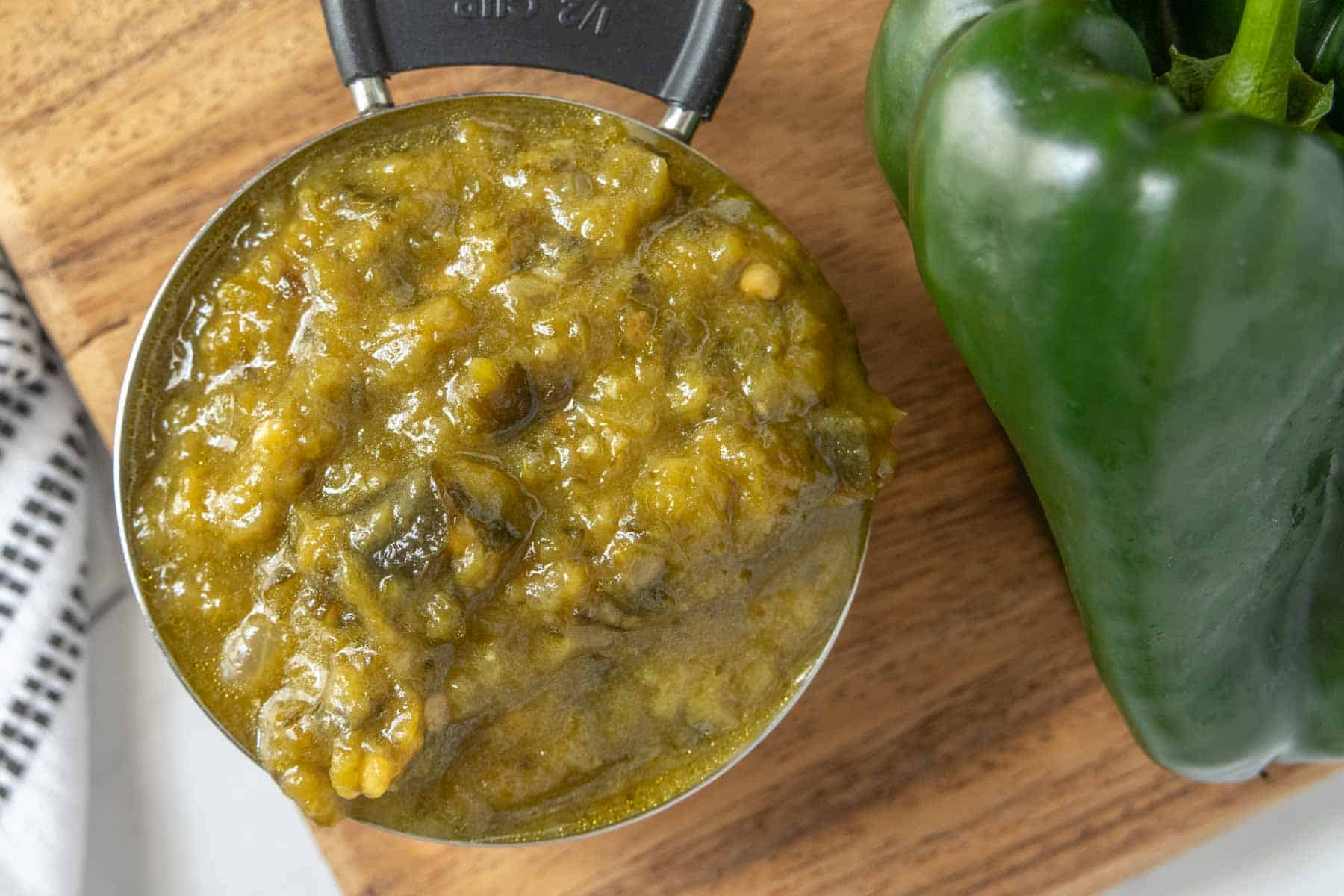 A spoonful of green pepper sauce on a cutting board.