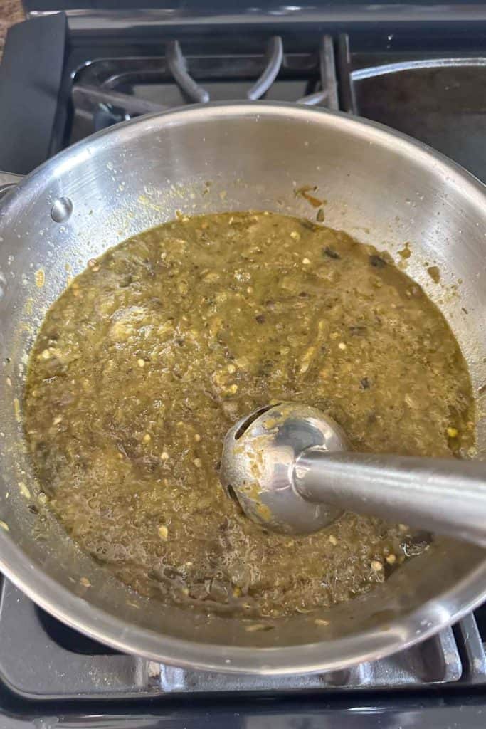 A pan full of green sauce on a stove top.