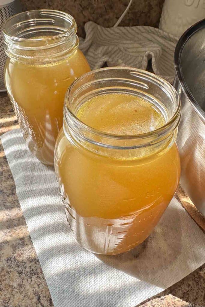 Two jars of chicken broth sitting on top of a towel.