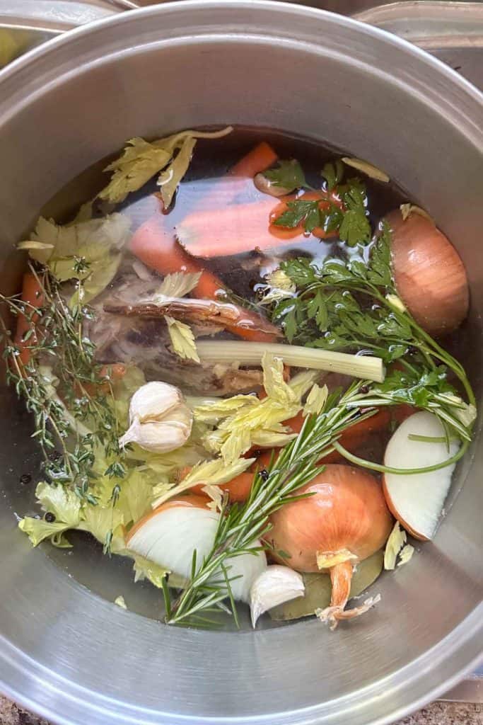 A pot full of vegetables and herbs in a pot.