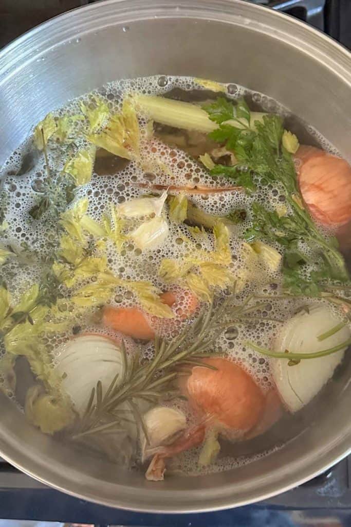 A pot filled with vegetables and broth on the stove.