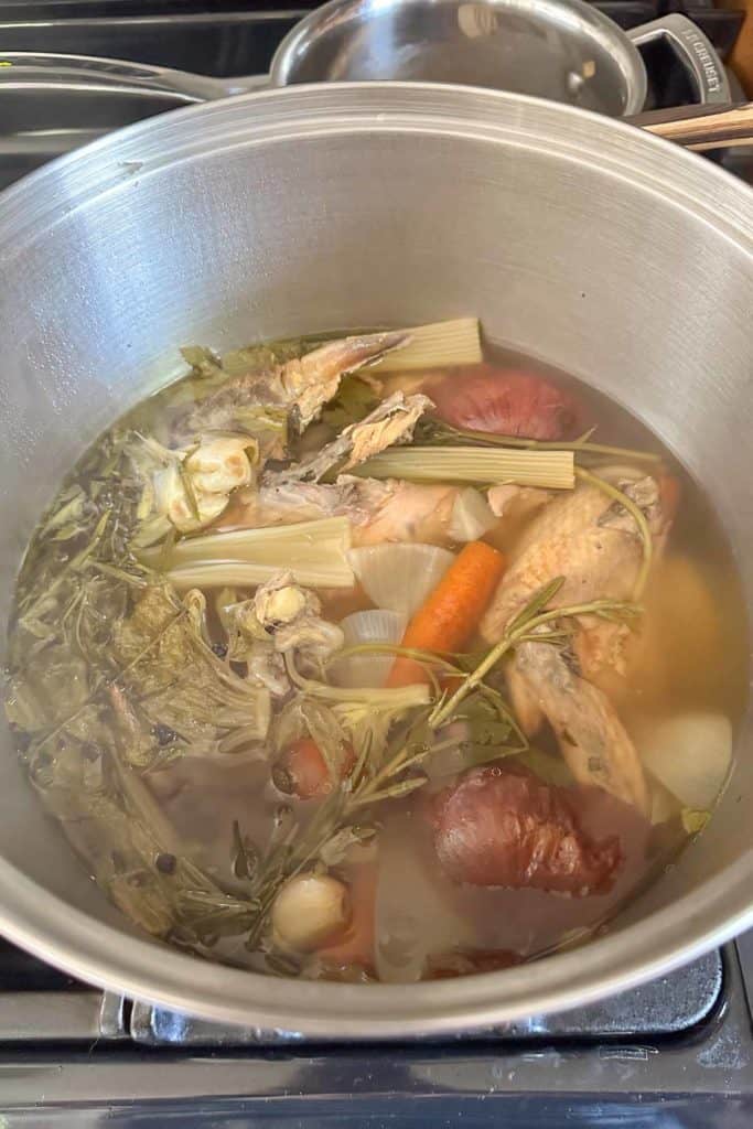 A pot filled with vegetables and meat on a stove.