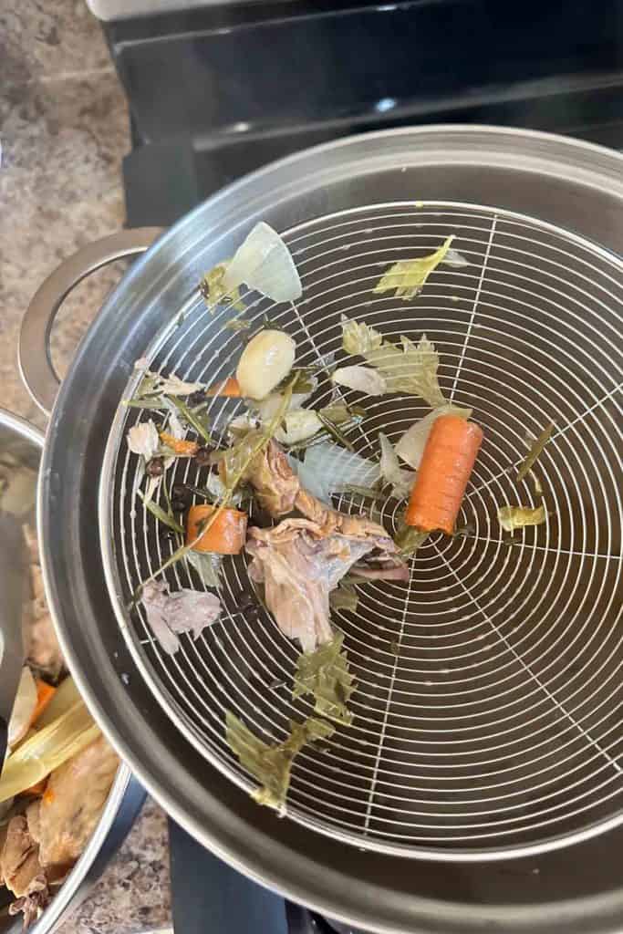 A pan with carrots and vegetables on top of it.