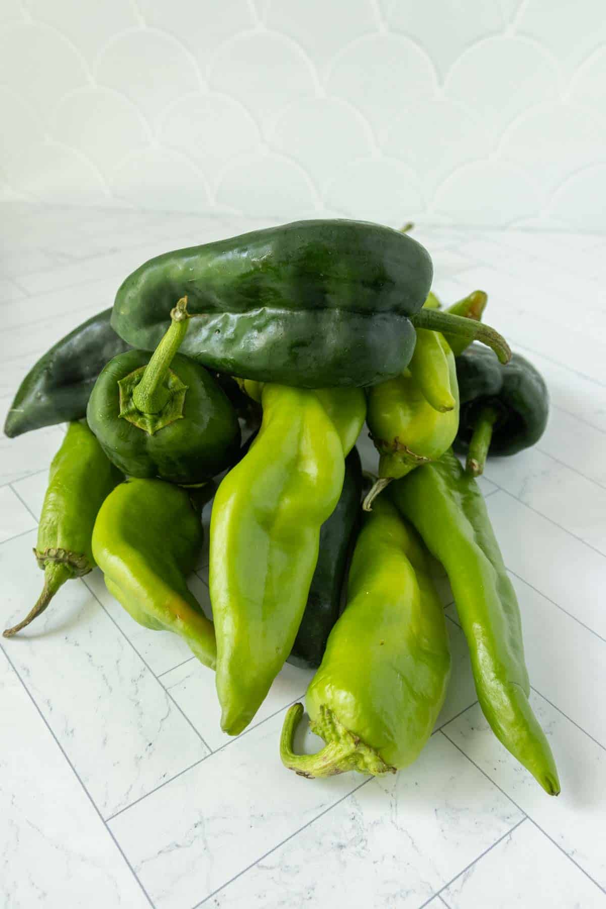 A pile of green peppers on a table.