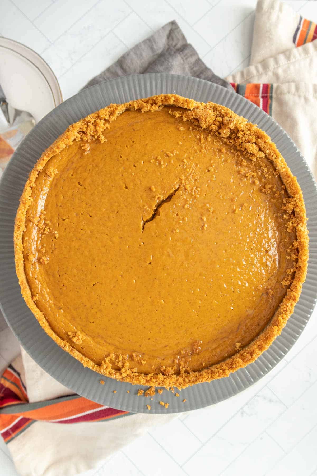 A pumpkin pie on a plate with a fork.