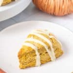 Pumpkin scones with icing on a plate.
