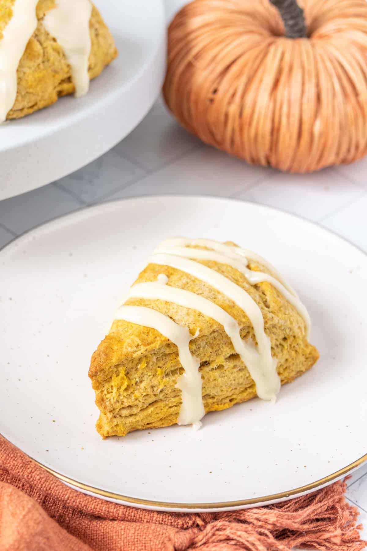 Pumpkin scones with icing on a plate.