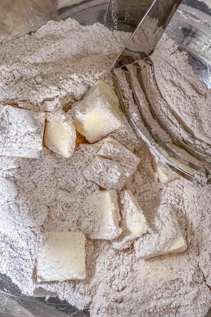 A bowl filled with flour, sugar, and butter.