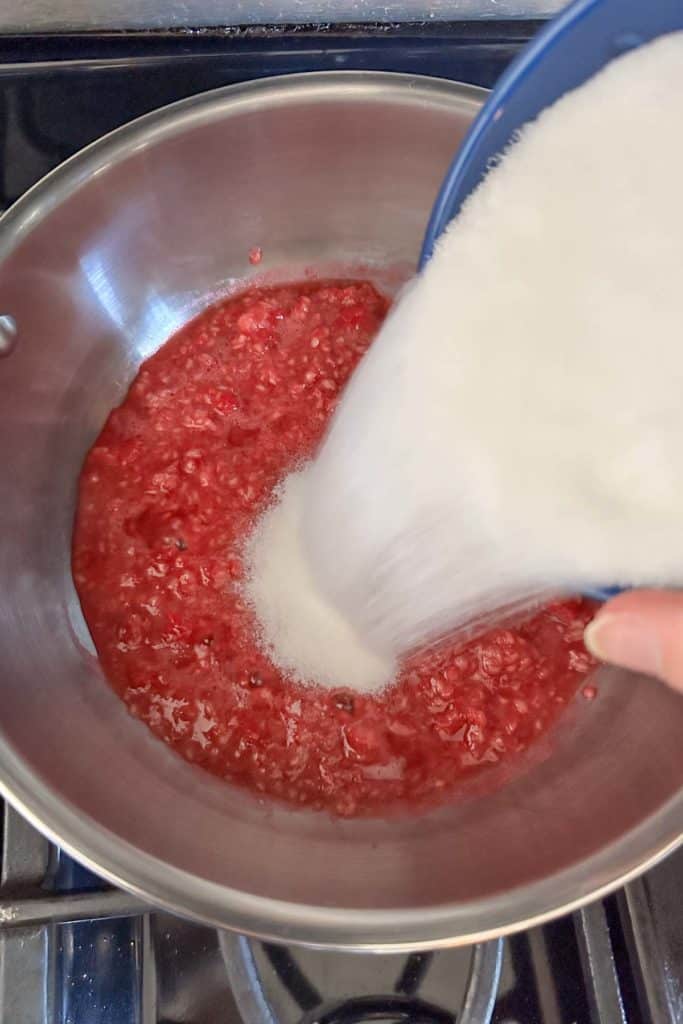 A person is pouring sugar into a pan.