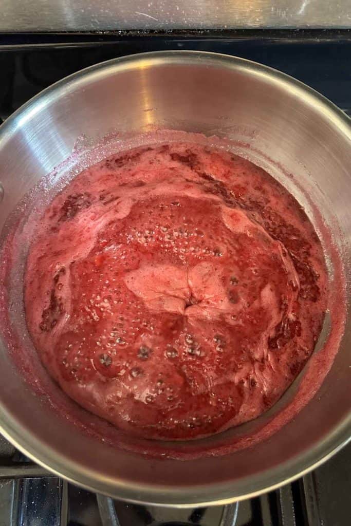 A pot with red liquid on top of a stove.