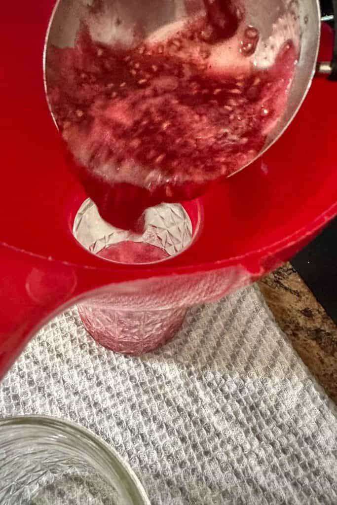 A red bowl with a red liquid in it.