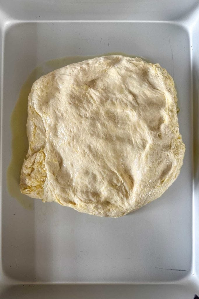 A piece of dough is sitting on a baking sheet.
