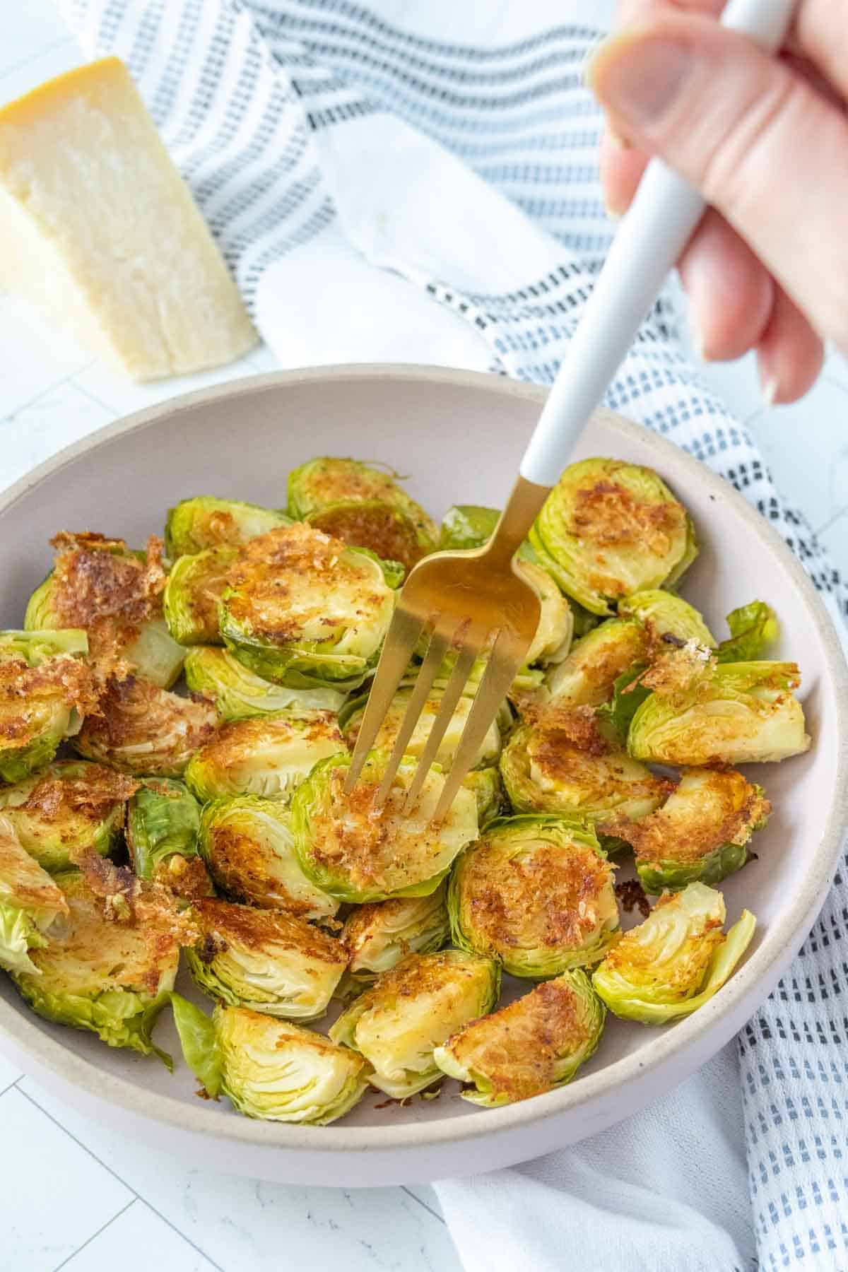 Brussels sprouts on a plate with a fork.